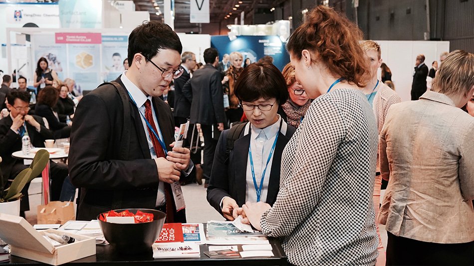 Three persons having a discussion at a exhibition